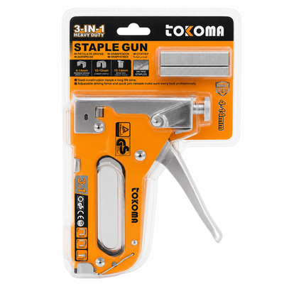 A Tokoma 3-in-1 heavy duty staple gun in its original retail blister packaging. The product features a bright orange body with silver metal components, including the staple bit, lever, and guide rail, set against a black and orange header card.